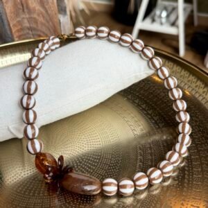 Collier ARIANA marron et ivoire avec perles rayées et éléments décoratifs ambrés porté autour du cou